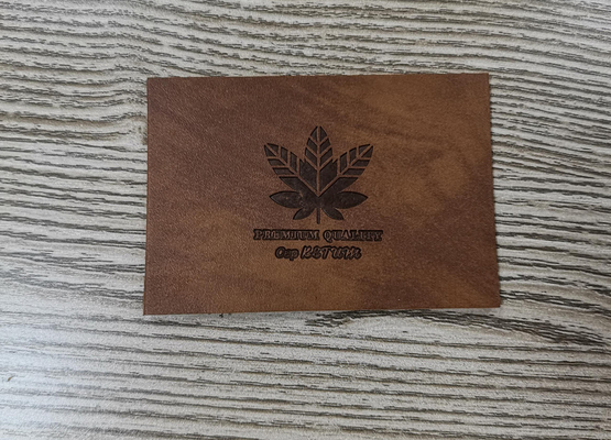 Naai op de Flardenkledingstuk van het Kledingspu Leer etiketteert In reliëf gemaakt Embleem